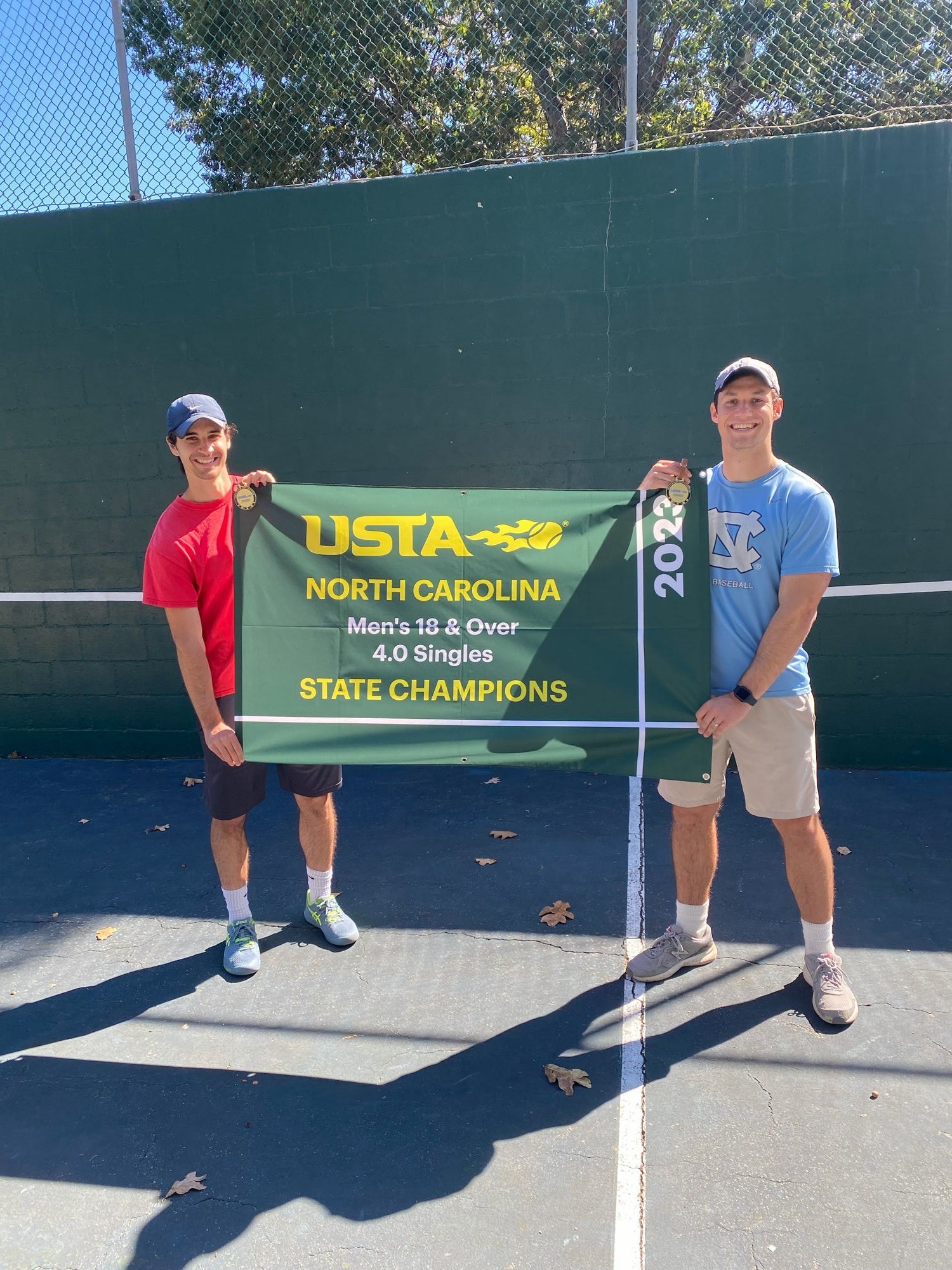 Jackson and Jeron with the USTA NC 4.0 State Champions banner